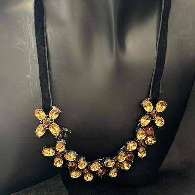 Black leather choker necklace with brown or tan colored gems on flowers