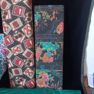BOLTS OF SEWING MATERIAL AND A THROW BLANKET THAT FOLDS INTO ITSELF