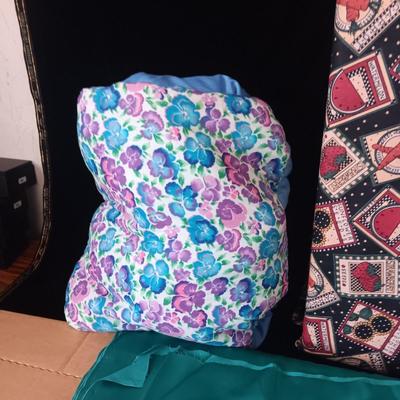 BOLTS OF SEWING MATERIAL AND A THROW BLANKET THAT FOLDS INTO ITSELF