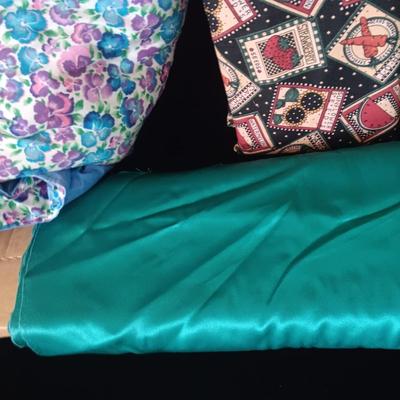 BOLTS OF SEWING MATERIAL AND A THROW BLANKET THAT FOLDS INTO ITSELF