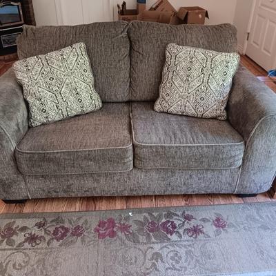 Ashley Furniture Industries Small Sofa with Footstool and two throw pillows