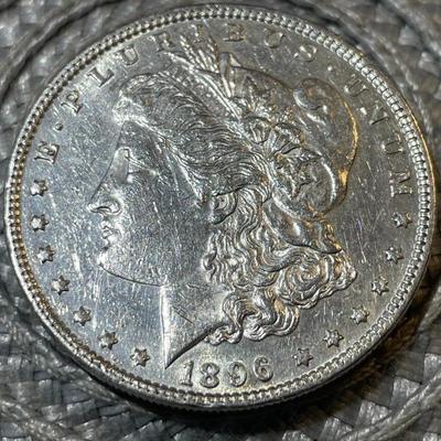 1896-P AU CONDITION/CLEANED MORGAN SILVER DOLLAR (COIN #6) AS PICTURED.