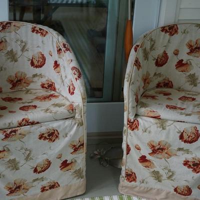 PAIR OF WICKER SIDE CHAIRS NATURAL COLOR THAT ALSO COMES WITH FLORAL SLIP COVERS AND CUSHION