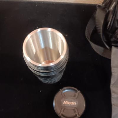 A CAMERA CASE AND A METAL BEVERAGE CUP RESEMBLING A CAMERA LENS