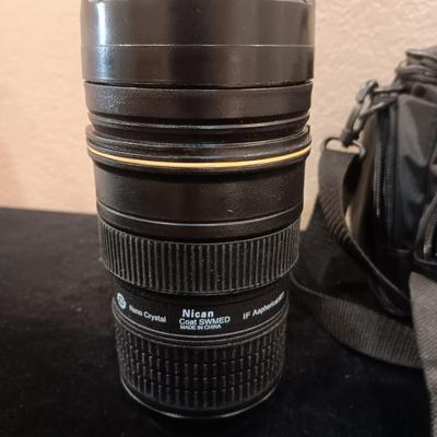 A CAMERA CASE AND A METAL BEVERAGE CUP RESEMBLING A CAMERA LENS