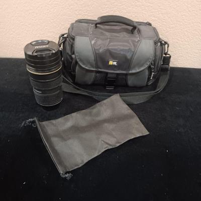 A CAMERA CASE AND A METAL BEVERAGE CUP RESEMBLING A CAMERA LENS