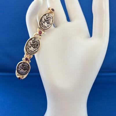 14K and Sterling silver bracelet with 6 embossed silver scenes and 7 amethyst cabachons Safety latch