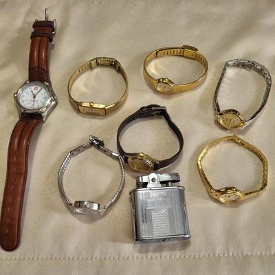 A GROUP OF WATCHES THAT NEED NEW BATTERIES AND A LIGHTER