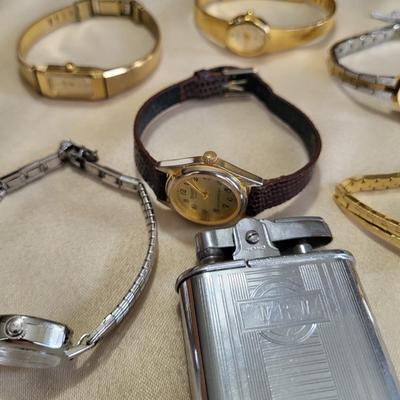 A GROUP OF WATCHES THAT NEED NEW BATTERIES AND A LIGHTER