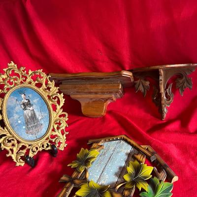 Variety of picture frames along with two small wall shelves for figurines or candles