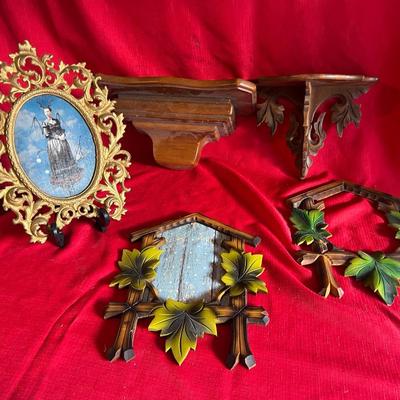Variety of picture frames along with two small wall shelves for figurines or candles