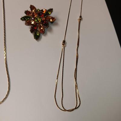 RHINESTONE BROOCH AND 2 GOLD TONE CHAINS