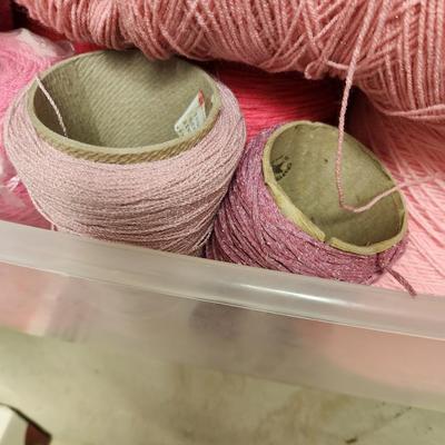 18 cones of yarn in pinks