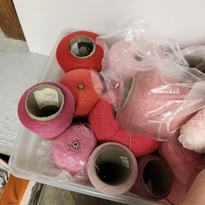 18 cones of yarn in pinks