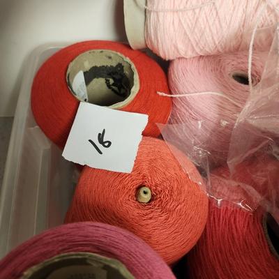18 cones of yarn in pinks