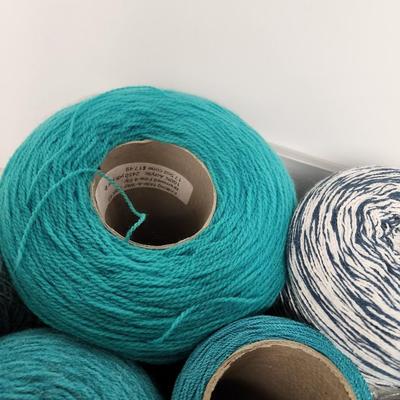 16 cones of yarn in aqua