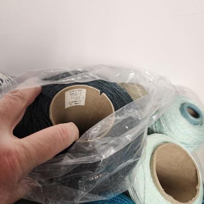 16 cones of yarn in aqua