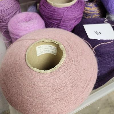 16 cones of yarn in purple