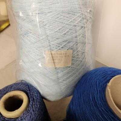 16 cones of yarn in blue