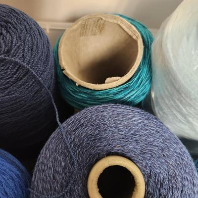 16 cones of yarn in blue