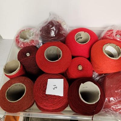 13 cones of yarn in red