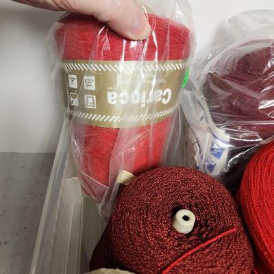 13 cones of yarn in red