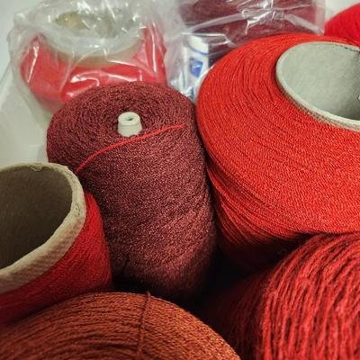 13 cones of yarn in red