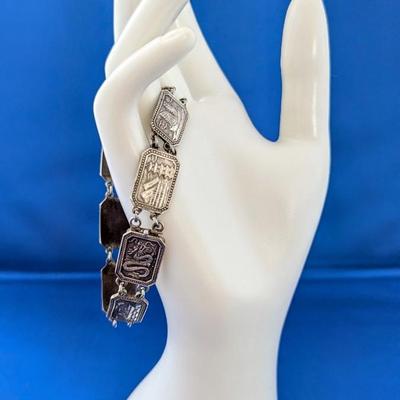 Antique silver link bracelet with different scenes or characters on each link
