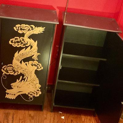 2 black cabinets with gold dragons, have shelves for storage