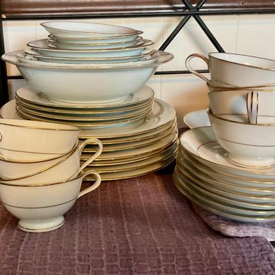 Large set of white dishes with gold trim
