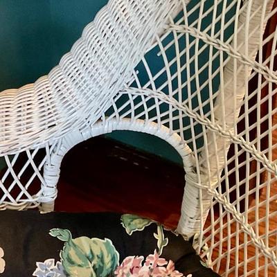 White wicker rocking chair, has floral cushion, some damage shown in pictures