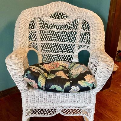White wicker rocking chair, has floral cushion, some damage shown in pictures