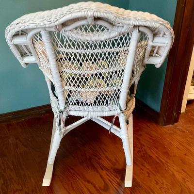 White wicker rocking chair, has floral cushion, some damage shown in pictures