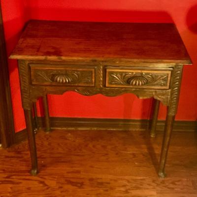 2 drawer antiqued pegged table with carved front and shell drawer pulls