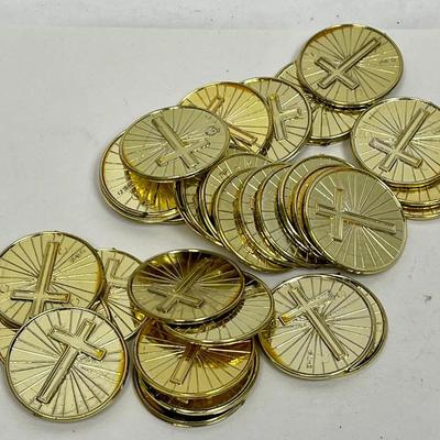 pile of plastic gold coins with crosses on both sides