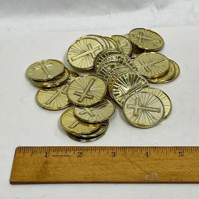 pile of plastic gold coins with crosses on both sides