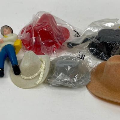 Miniature Cowboy Hats, a Top Hat with Cane, and a small plastic Fisherman Cake Topper figurine