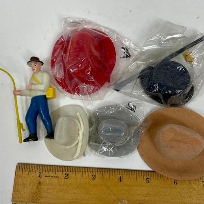 Miniature Cowboy Hats, a Top Hat with Cane, and a small plastic Fisherman Cake Topper figurine