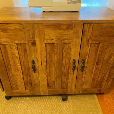 Modern sewing machine cabinet on casters