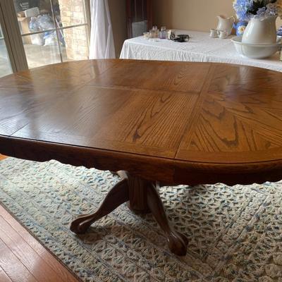 Beautiful vintage solid oak clawfoot pedestal dining table with one 24” leaf