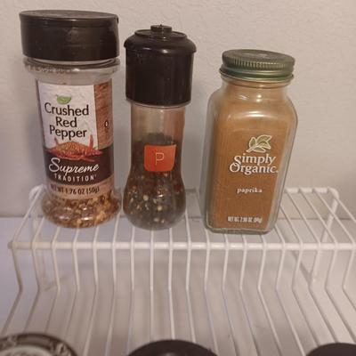 Assortment of lightly used kitchen spices with spice organizer - pottery butter dish - and Pyrex measuring cup