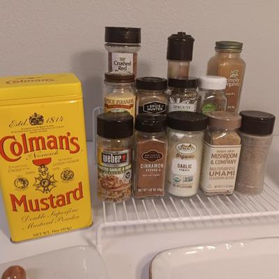 Assortment of lightly used kitchen spices with spice organizer - pottery butter dish - and Pyrex measuring cup