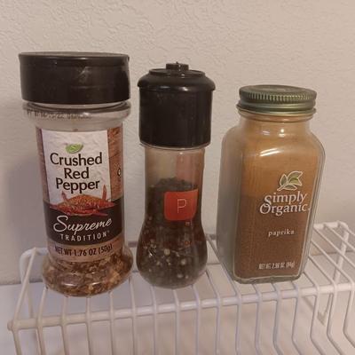 Assortment of lightly used kitchen spices with spice organizer - pottery butter dish - and Pyrex measuring cup
