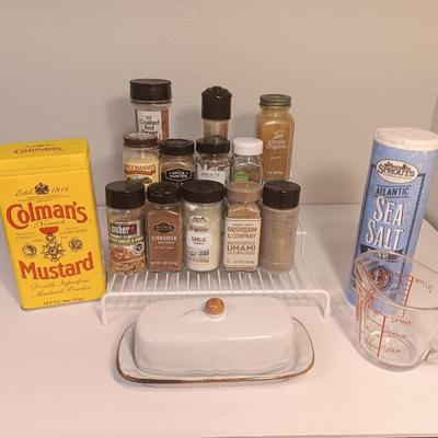 Assortment of lightly used kitchen spices with spice organizer - pottery butter dish - and Pyrex measuring cup