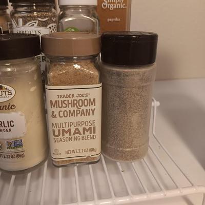 Assortment of lightly used kitchen spices with spice organizer - pottery butter dish - and Pyrex measuring cup