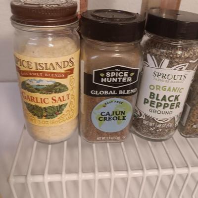 Assortment of lightly used kitchen spices with spice organizer - pottery butter dish - and Pyrex measuring cup