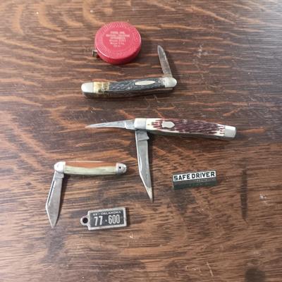 3 POCKET KNIVES, DAV PLATE, TAPE MEASURE AND METAL PIN
