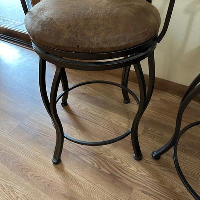 2 IRON SWIVEL BAR STOOLS WITH RAWHIDE CUSHIONED SEATS
