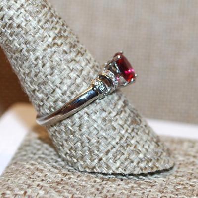 Size 9¼ Marked .925 Size 8¼ Oval Cranberry Red Stone Ring with Side Accent "Clips" on a Silver Band (2.4g)