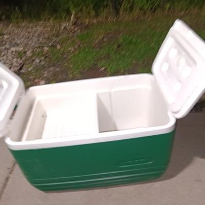 Green Igloo cooler with black umbrella